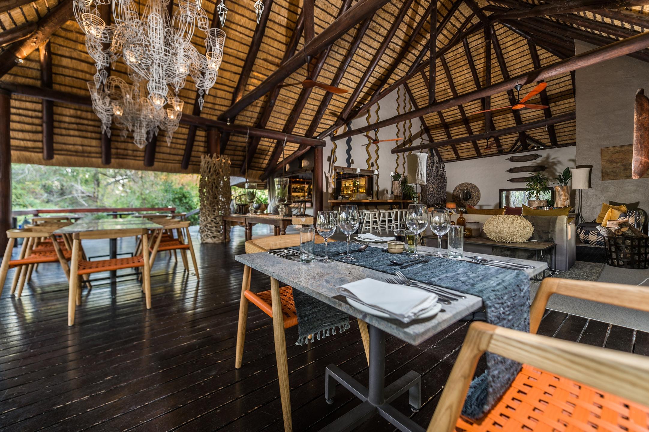 <p>The bar area at Little Bush Camp is decorated with natural materials and African-inspired decor, including traditional woven baskets and artwork depicting local wildlife.</p>